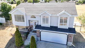 Raised ranch with brick siding and a shingled roof