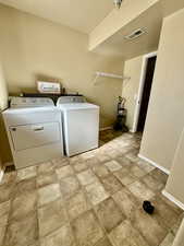 Washroom featuring independent washer and dryer and baseboards