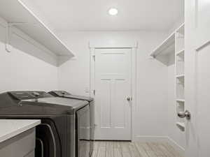 Washroom with washer and clothes dryer and wood tiled floors