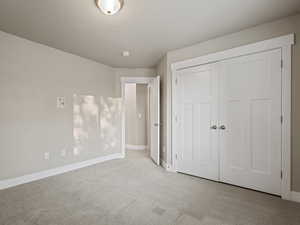 Unfurnished bedroom featuring carpet, a closet, and a textured ceiling
