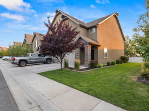 View of front facade featuring stone siding, concrete driveway, stucco siding, and a garage