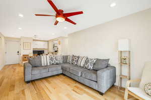Living area with light wood finished floors, recessed lighting, ceiling fan, and a desk