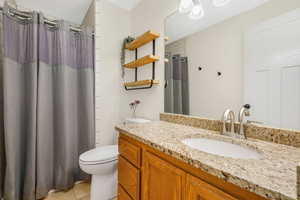 Full bathroom with vanity, light tile patterned floors, and a shower with curtain