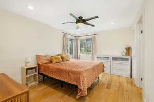 Bedroom featuring light wood-type flooring, a ceiling fan, and recessed lighting