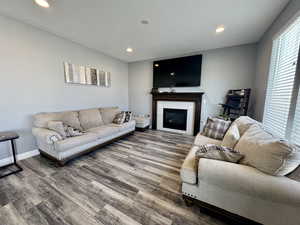 Living area featuring a tile fireplace, recessed lighting, and wood finished floors