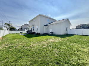Rear view of house featuring a fenced backyard and stucco siding
