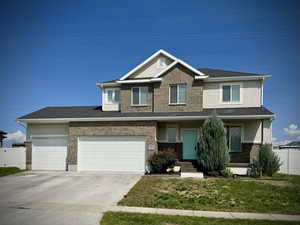 Craftsman-style house with covered porch, concrete driveway, stucco siding, and brick siding