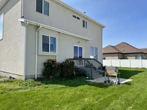 Back of property with stucco siding, a patio area, and a wooden deck