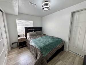 Bedroom with a textured ceiling and light wood-style floors