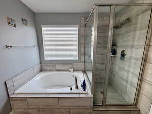 Primary Bathroom featuring a shower stall and a garden tub