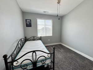 Carpeted bedroom featuring a textured ceiling and a ceiling fan