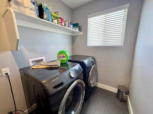 Laundry room with independent washer and dryer and baseboards
