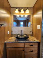 Bathroom with vanity and wooden walls