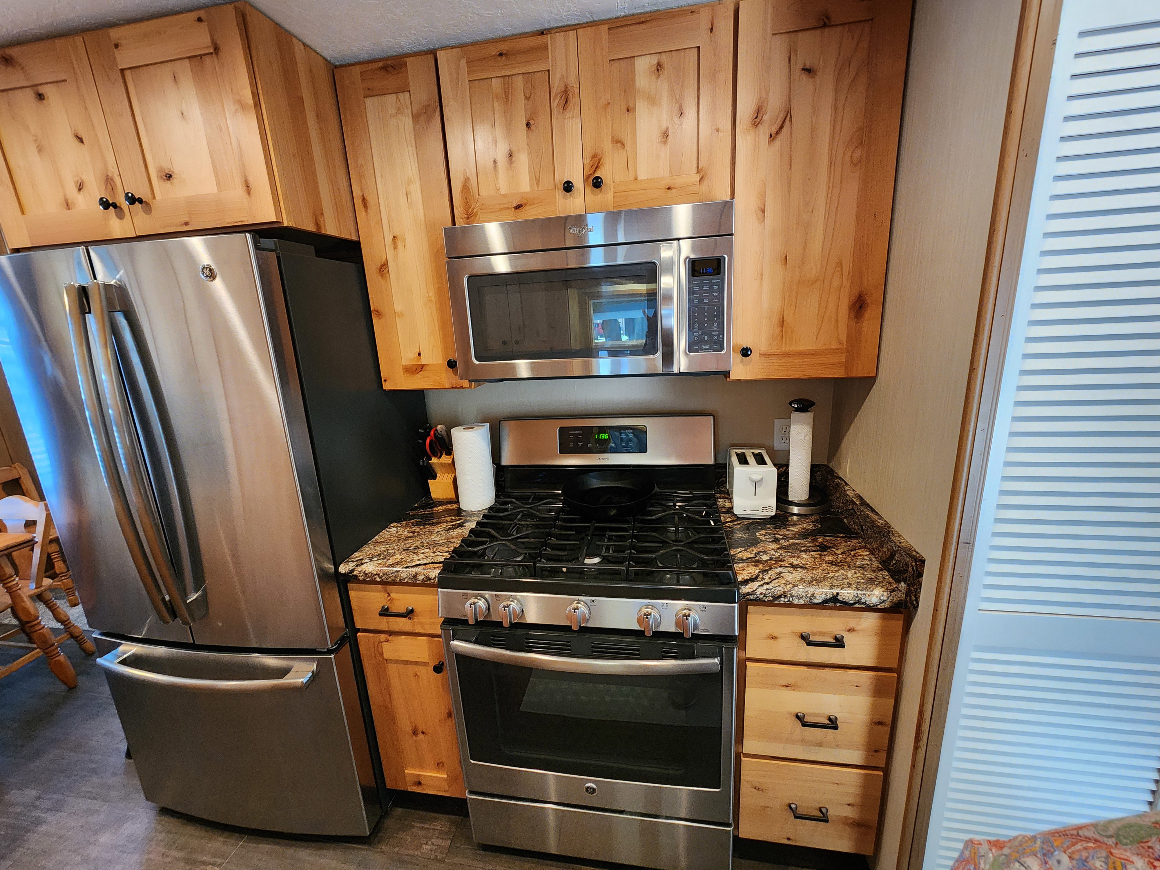 Kitchen featuring stainless steel appliances and dark stone countertops