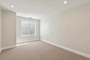 Empty room featuring light colored carpet and recessed lighting