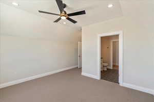 Unfurnished bedroom featuring vaulted ceiling, carpet floors, recessed lighting, a ceiling fan, and connected bathroom