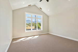 Spare room featuring carpet flooring, vaulted ceiling, a mountain view, recessed lighting, and a ceiling fan