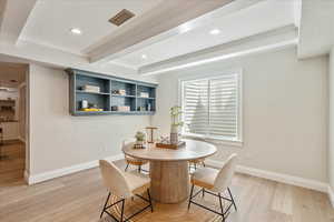 Dining space featuring beamed ceiling, light wood-style floors, ornamental molding, and recessed lighting