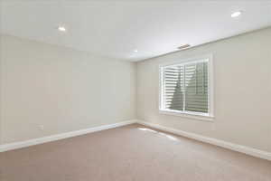 Empty room with carpet floors and recessed lighting