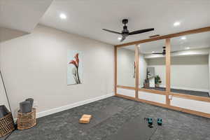 Exercise area with a ceiling fan, recessed lighting, and carpet flooring