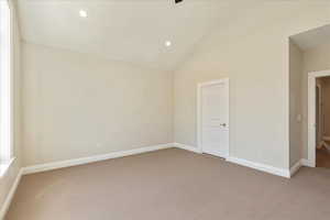 Spare room featuring light colored carpet, high vaulted ceiling, and recessed lighting