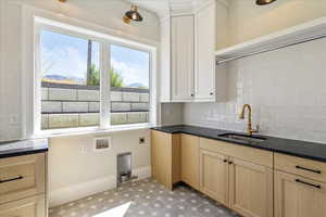 Washroom featuring healthy amount of natural light, cabinet space, washer hookup, and electric dryer hookup