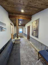 Living room featuring wainscoting, a wooden ceiling with exposed beams, and recessed lighting
