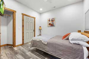 Bedroom featuring wood finished floors, a ceiling fan, and recessed lighting