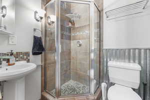 Bathroom with a stall shower and a wainscoted wall