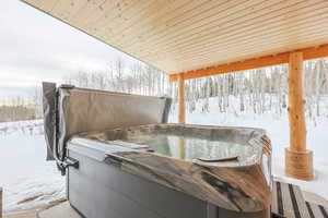 Snow covered patio with a hot tub