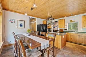 Dining area with arched walkways, wooden ceiling, and rail lighting