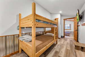 Bedroom featuring light wood finished floors, lofted ceiling, and recessed lighting