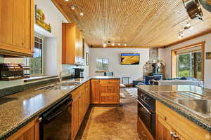 Kitchen with rail lighting, brown cabinets, a peninsula, healthy amount of natural light, and wooden ceiling