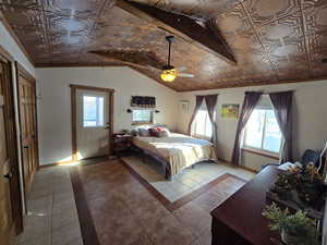 Tiled bedroom with multiple windows and a ceiling fan