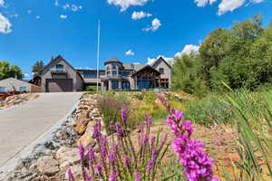 View of front of home with stone siding, concrete driveway, and a garage