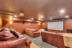 Home Theater room with a textured ceiling and carpet