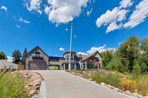 View of front of home featuring stone siding and driveway