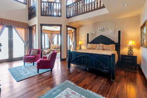 Primary Bedroom with a towering ceiling, dark wood-type flooring, and recessed lighting, Sitting room and fireplace with Mantle imported from Europe.