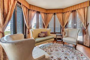 Primary bedroom sitting area with healthy amount of natural light and wood-type flooring
