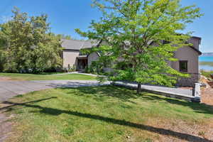 View of front of property featuring stucco siding, stone siding, and a front lawn