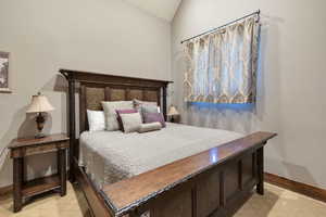 Bedroom with baseboards and lofted ceiling