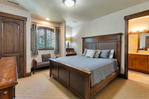 Bedroom featuring ensuite bathroom and a textured ceiling
