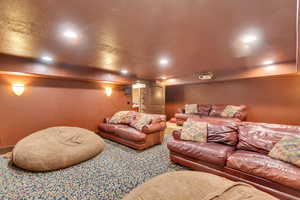 Home theater room with a textured ceiling and recessed lighting