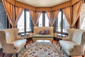 Primary bedroom sitting area featuring wood finished floors and healthy amount of natural light