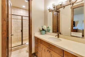 Jack n Jill bath with vanity, a shower stall, light tile patterned flooring, and recessed lighting