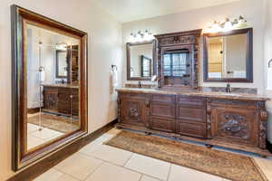 Primary Bathroom featuring double vanity and light tile patterned floors