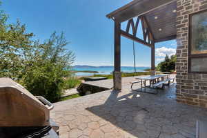 View of patio featuring a water and mountain view, outdoor dining area, and area for grilling