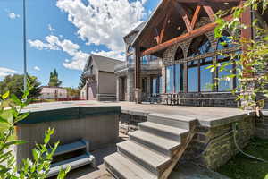 Rear view of property featuring a patio area and a hot tub