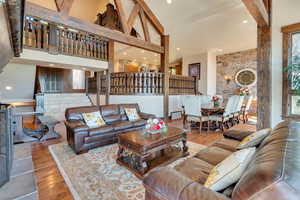 Living area featuring recessed lighting, hardwood / wood-style flooring, and a towering ceiling