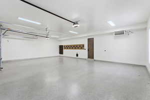 Garage featuring baseboards and a heating unit